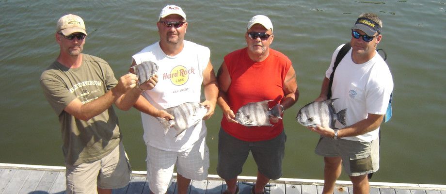 A group of people standing on the Taurus holding fish