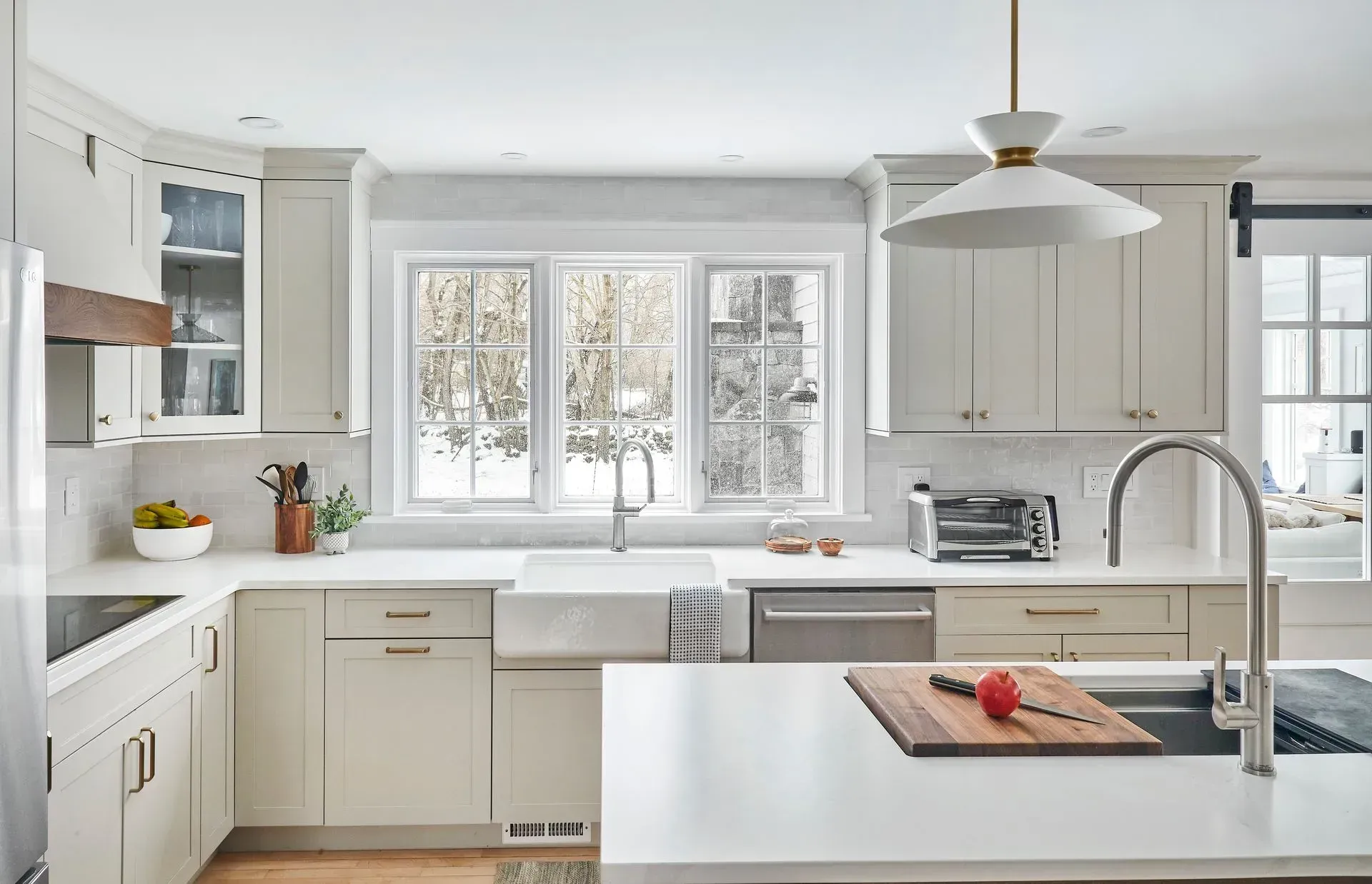 Modern kitchen with white cabinets, stainless steel appliances, and a farmhouse sink.