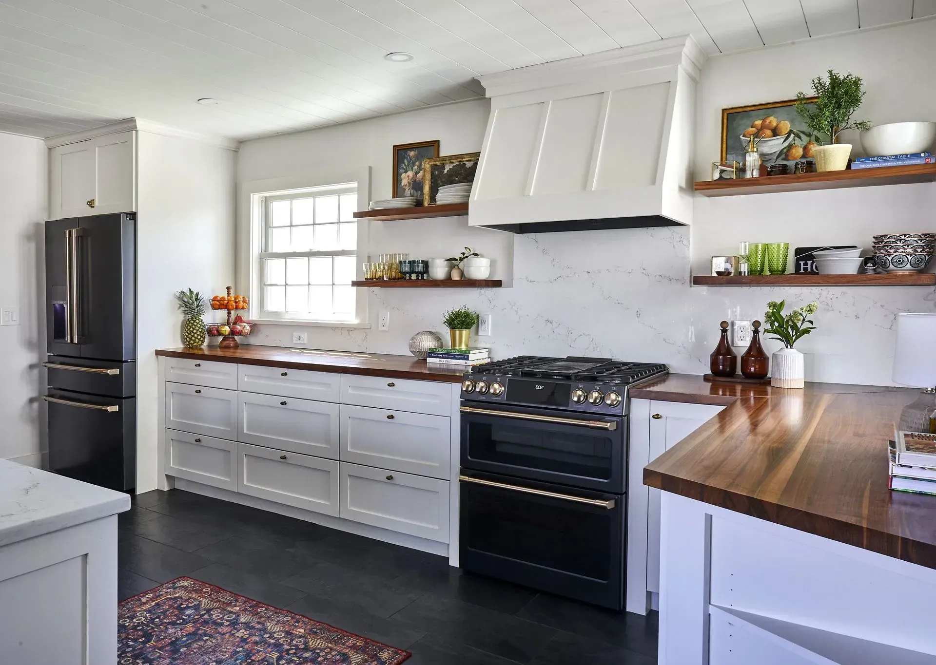 White kitchen with black accents, black range, dark wood countertops, open shelves, and dark flooring.