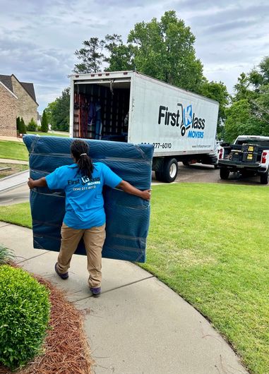 First Klass Movers employee moving furniture with a moving truck in Montgomery, Alabama