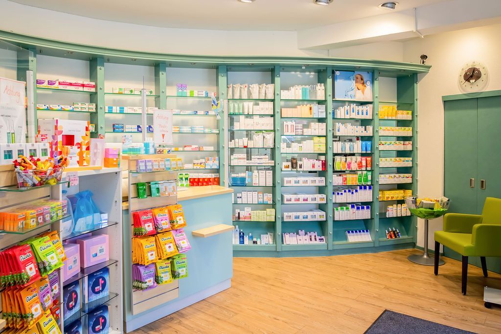 Das Innere einer Apotheke mit vielen Regalen und einem Wartebereich.