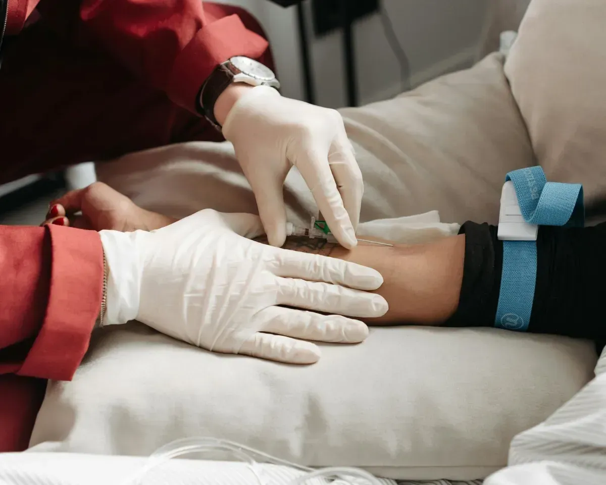 Hands giving a massage on a person's lower back under a white towel