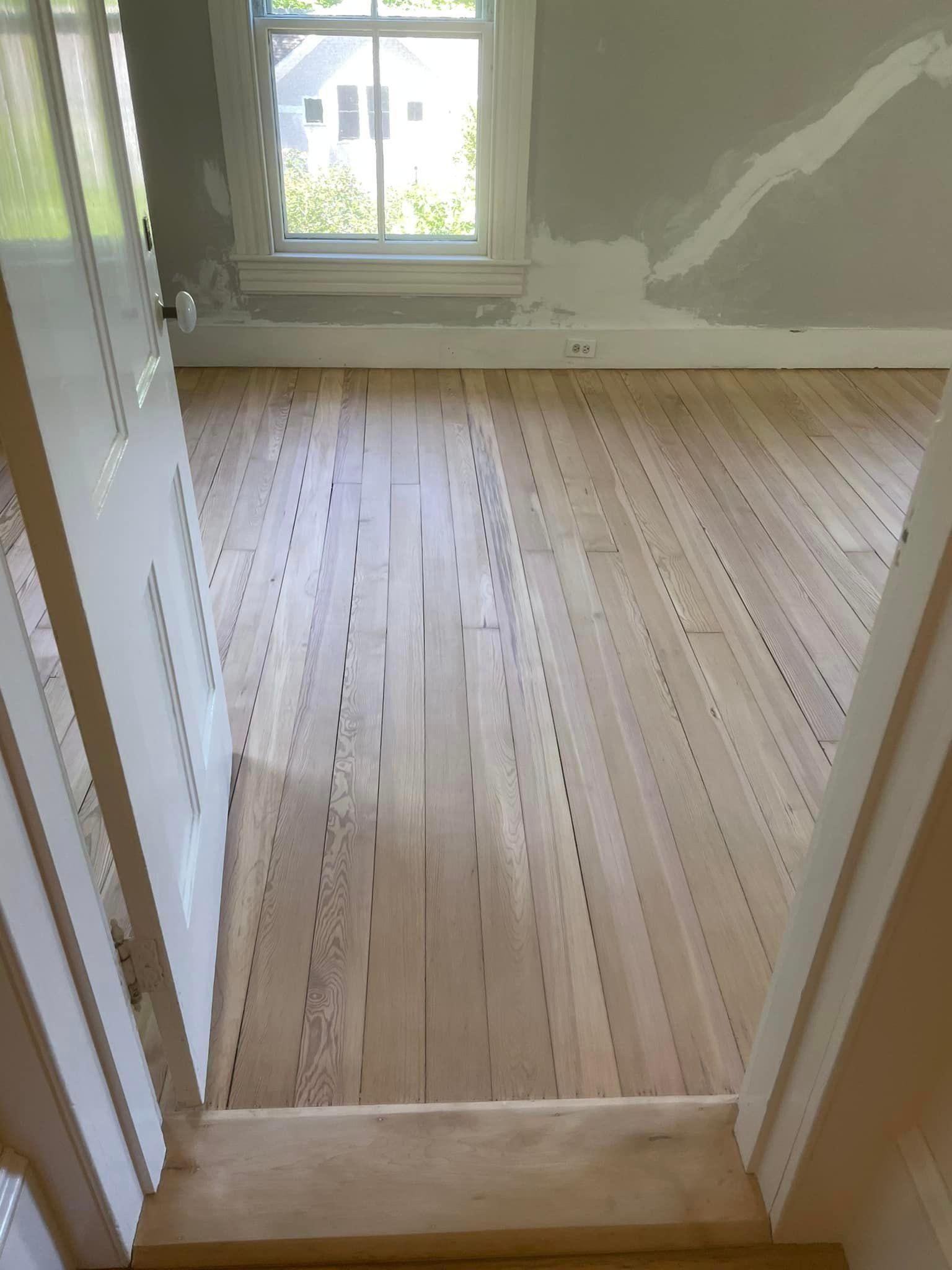 A room with a wooden floor and a window.