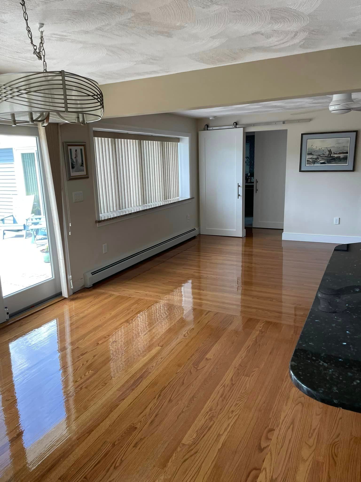 A living room with hardwood floors and a ceiling fan.