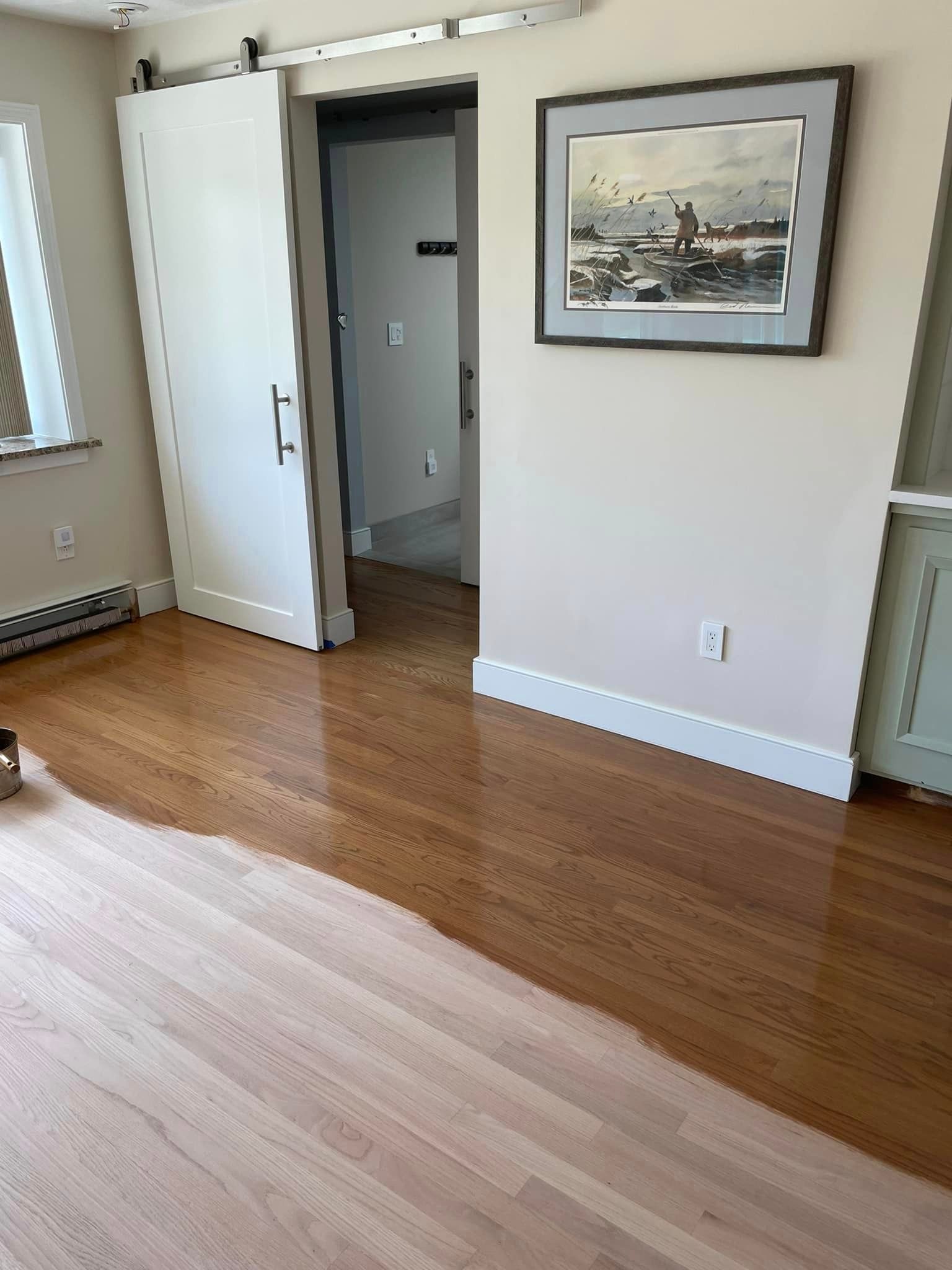 A room with hardwood floors and a picture on the wall.