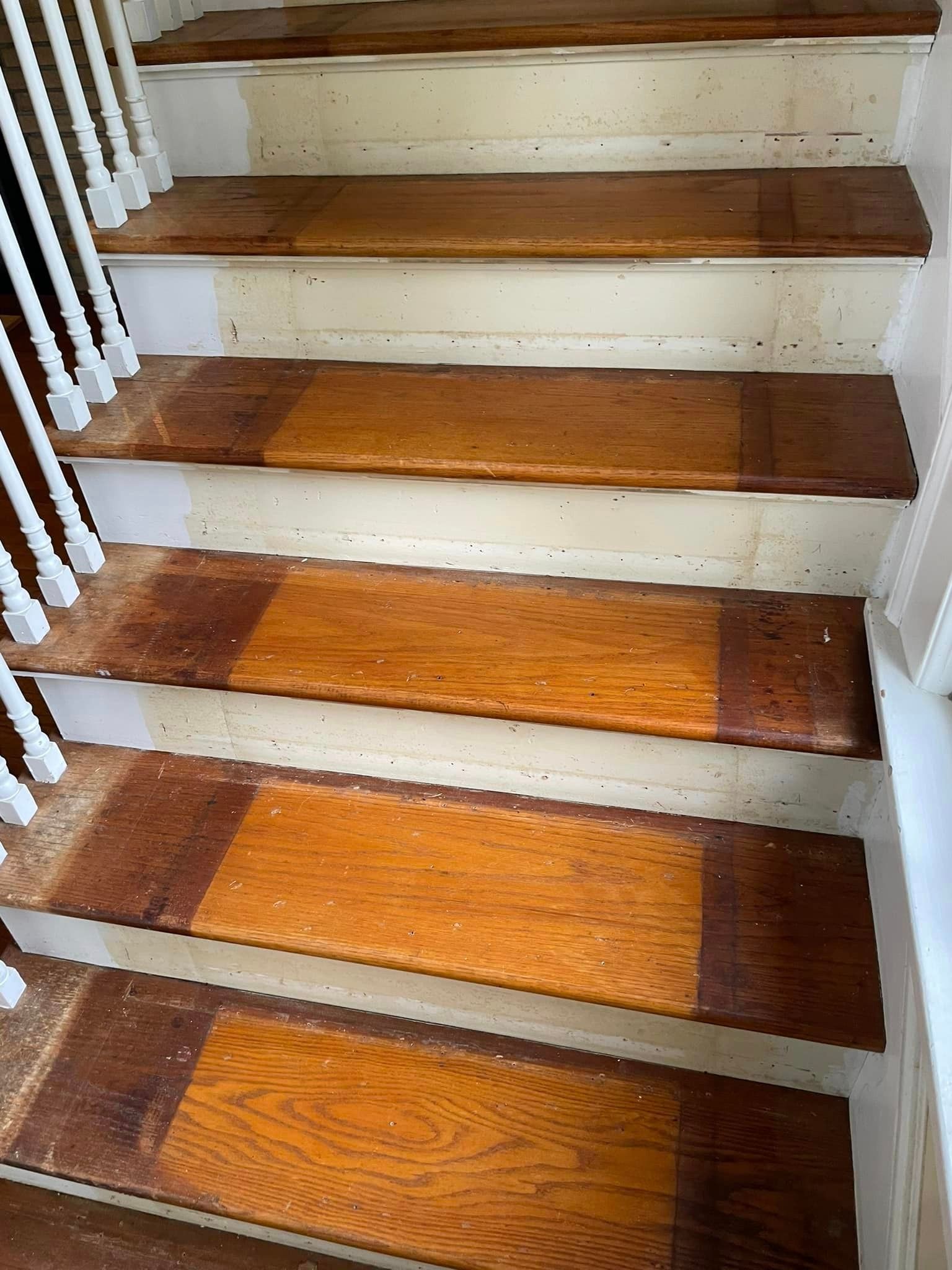 A set of wooden stairs with white railings in a house.