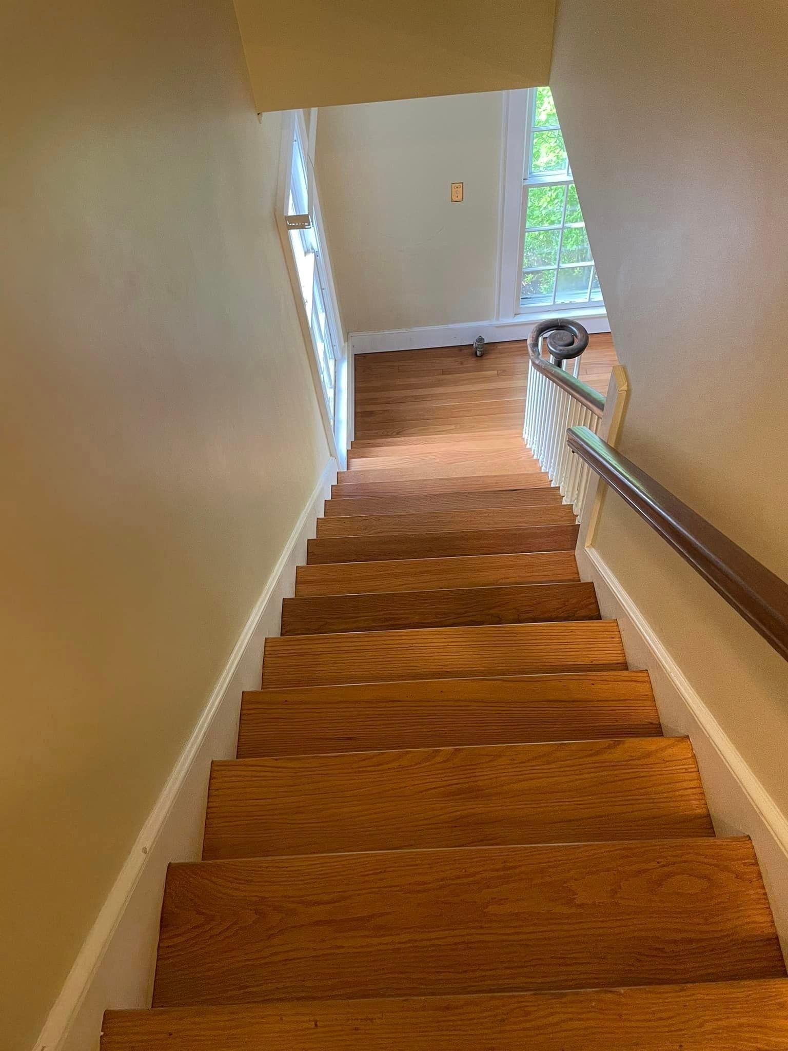 A set of wooden stairs leading up to the second floor of a house.