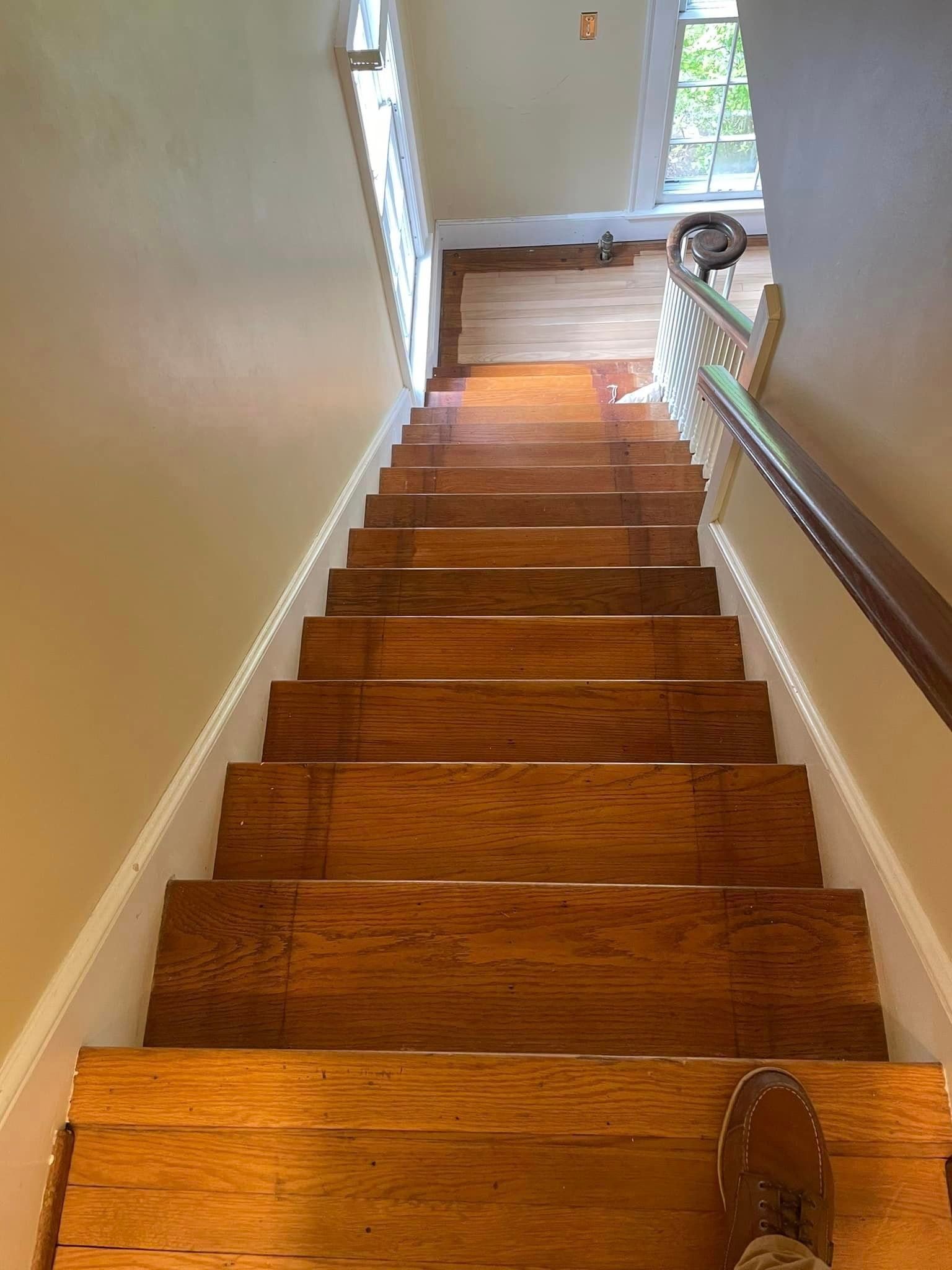 A person is standing on a set of wooden stairs.