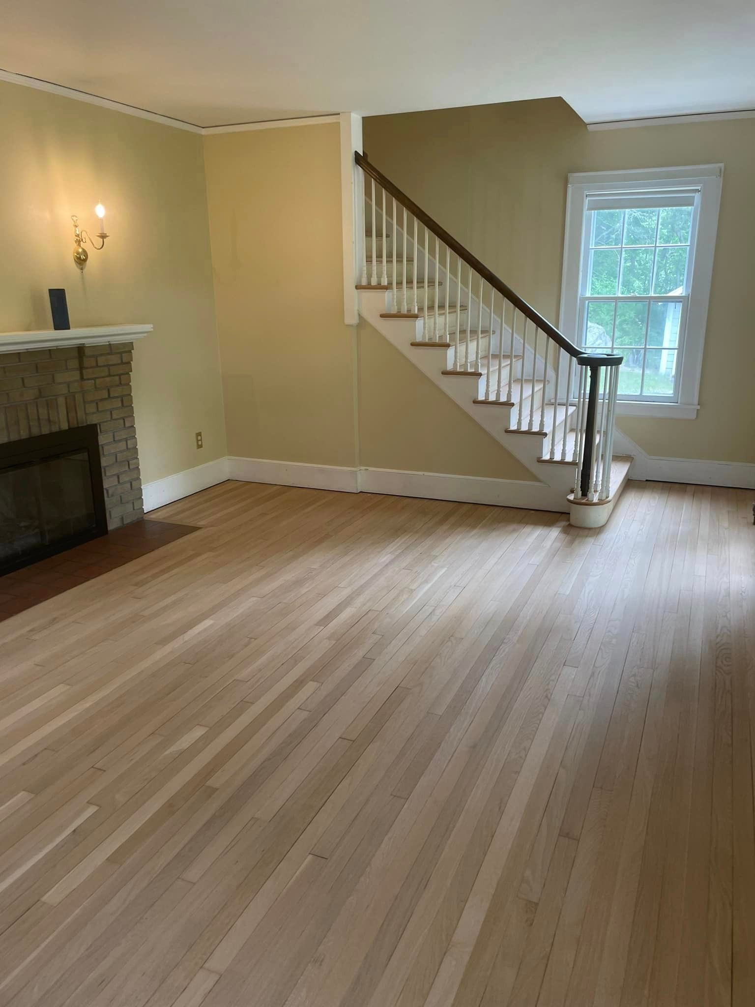 An empty living room with hardwood floors and stairs