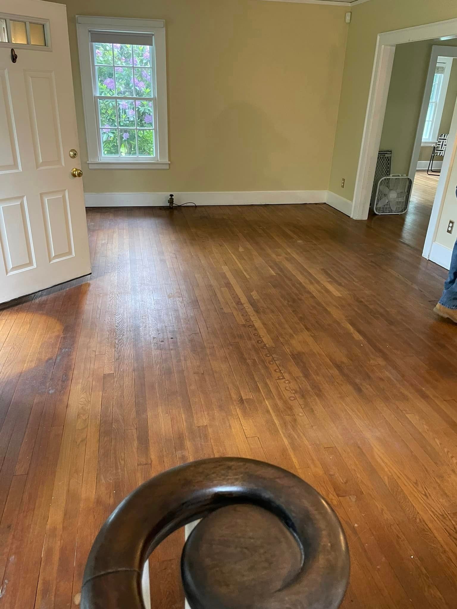 An empty living room with hardwood floors and a staircase.