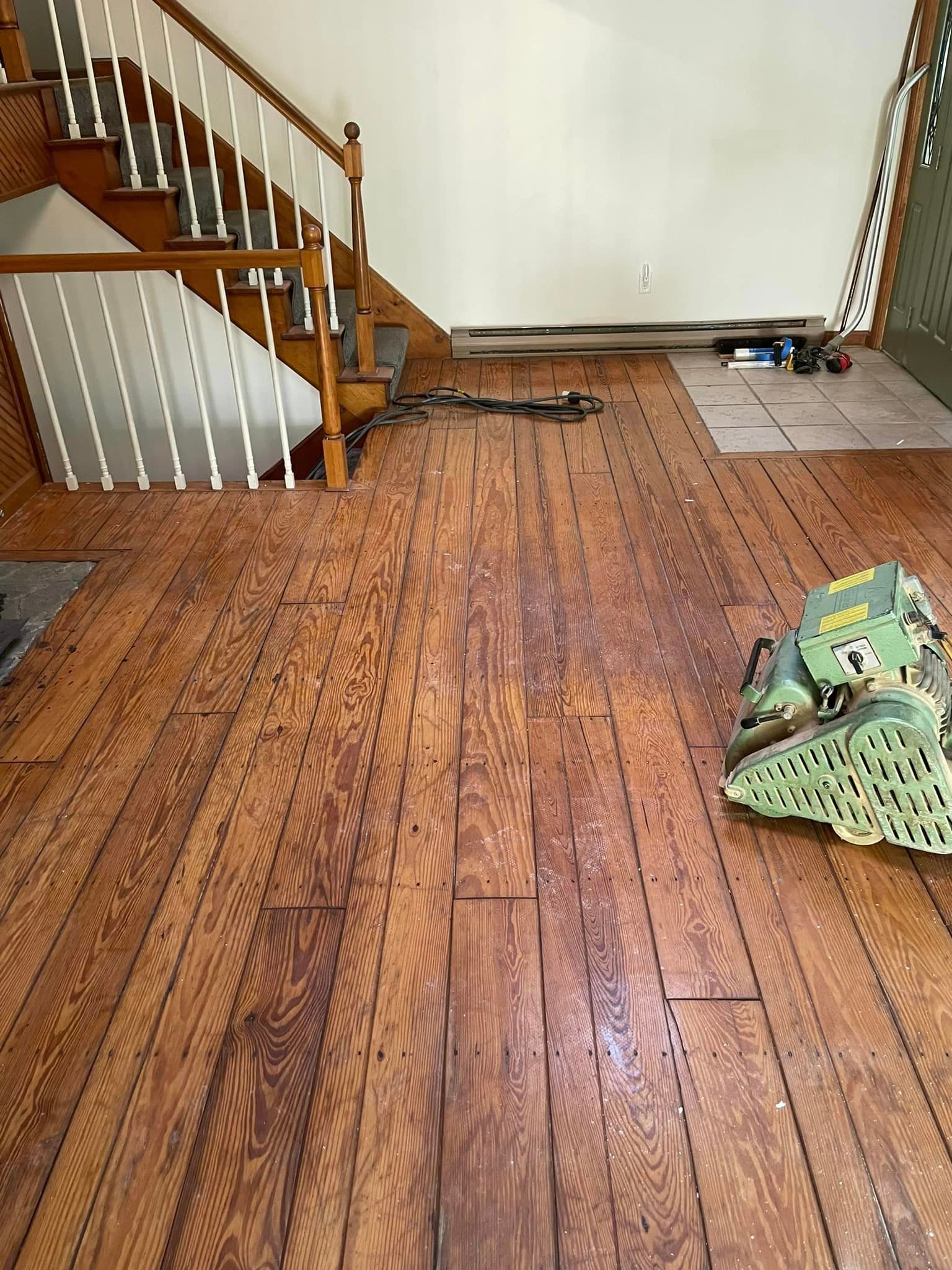 A wooden floor with a staircase in the background.