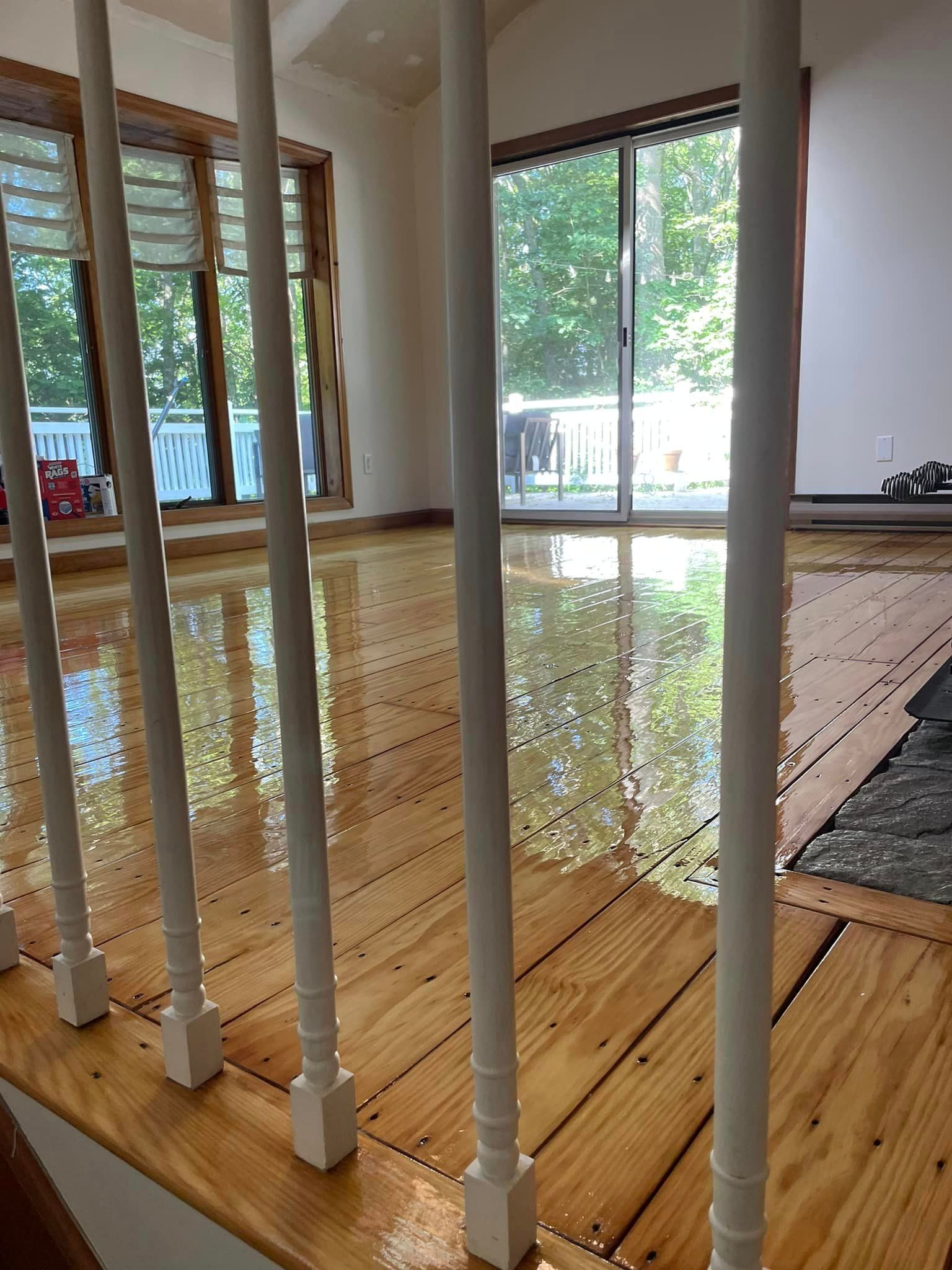 A wooden floor with a white railing in a living room.