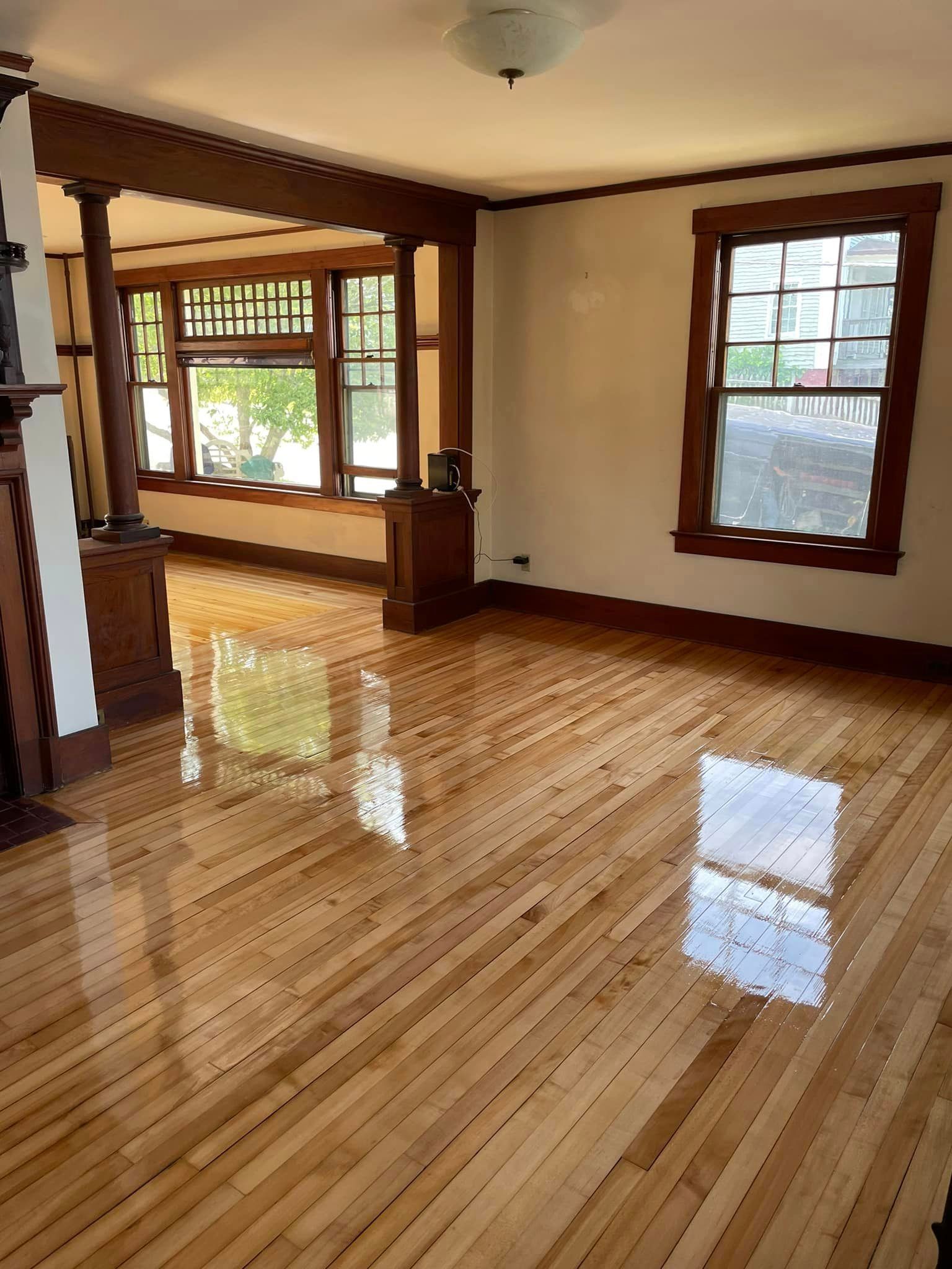 A living room with hardwood floors and lots of windows