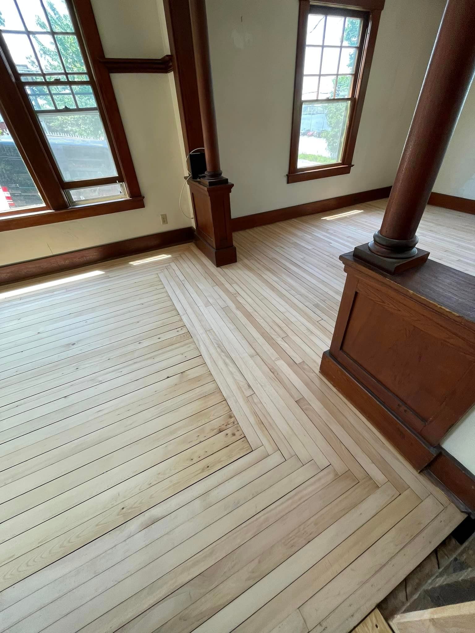 A room with a wooden floor and a lot of windows.