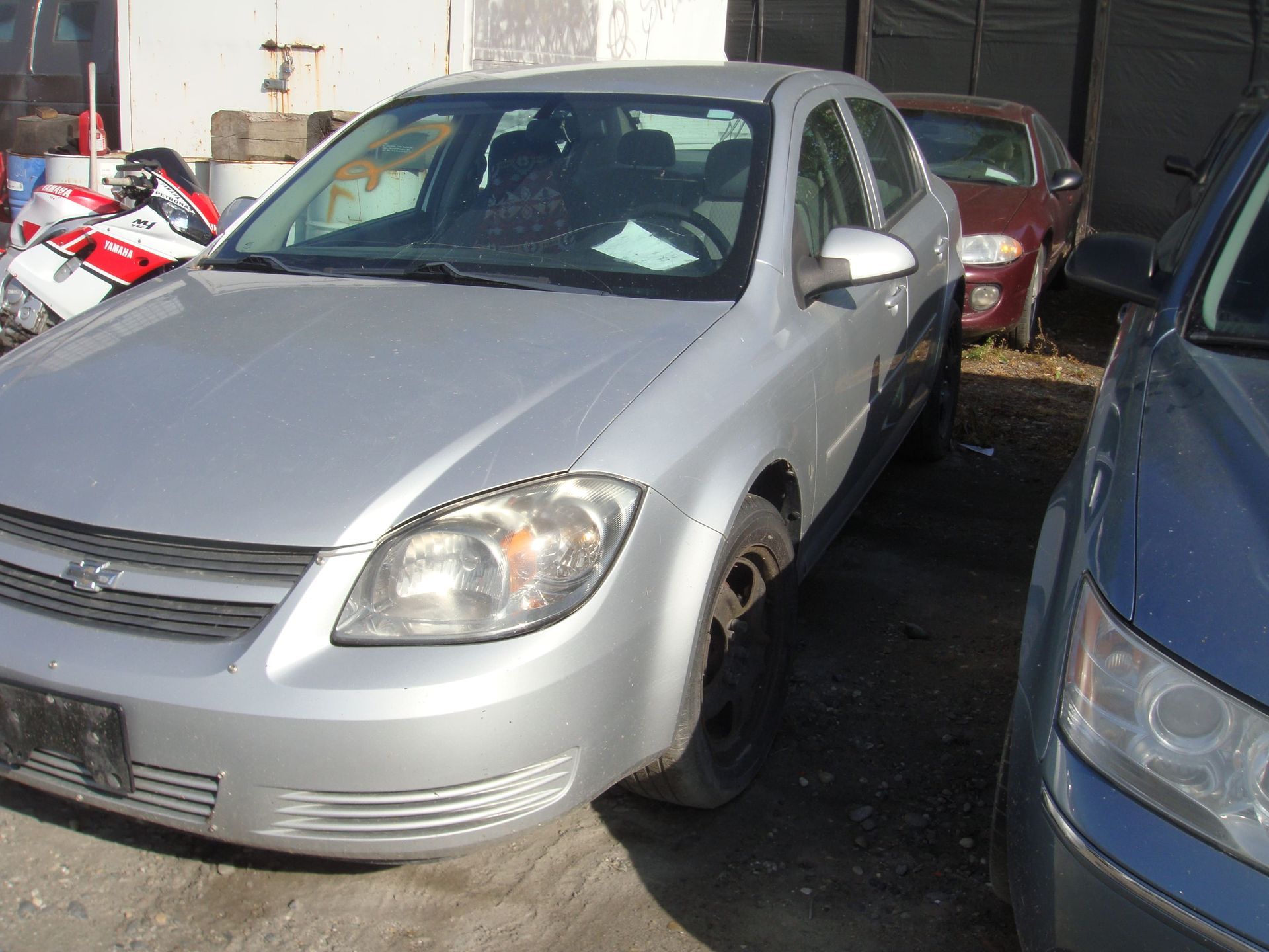 Silver sedan parked outdoors beside other cars in a lot