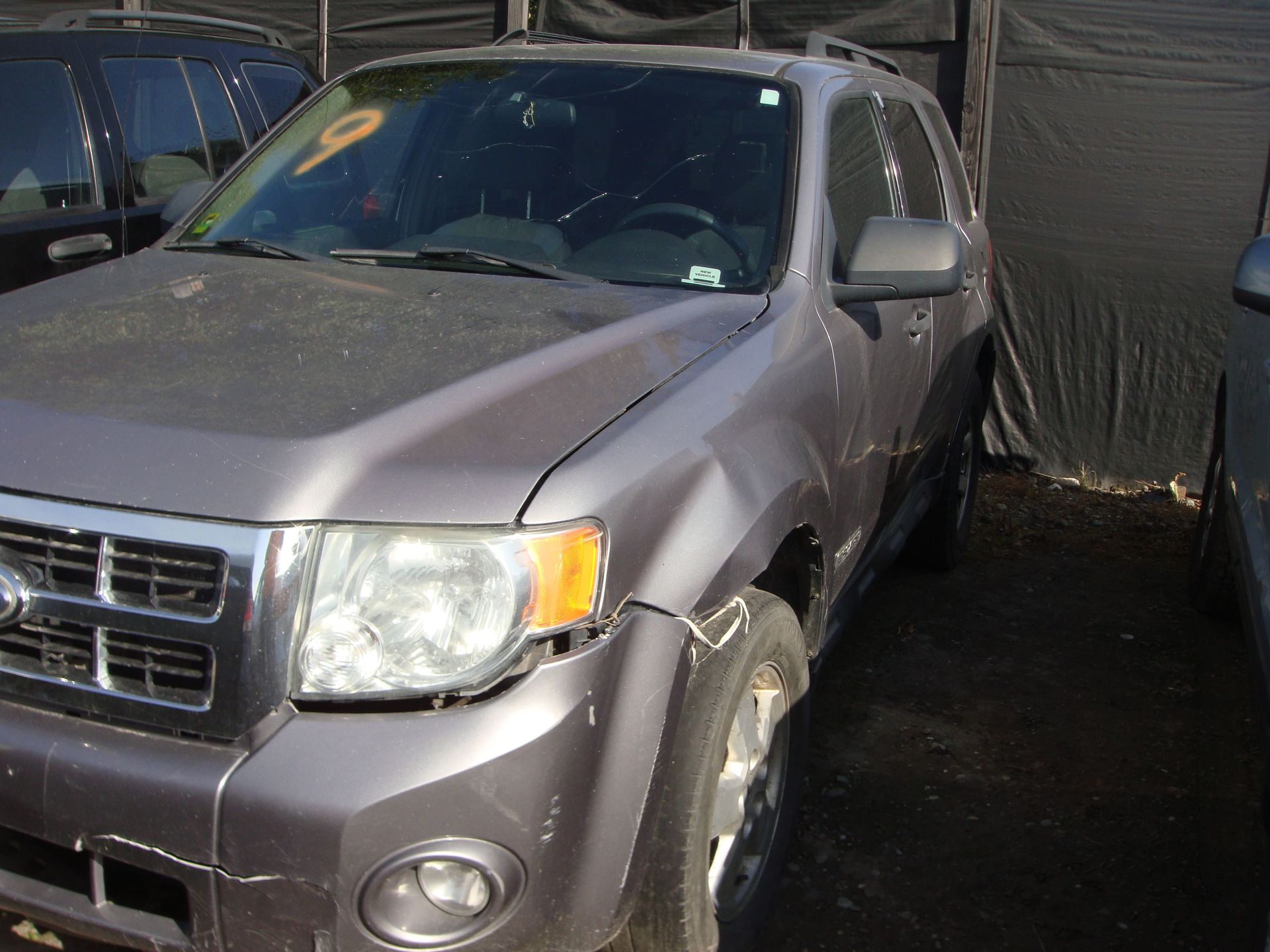 Gray SUV covered in dust, parked in a car wash bay
