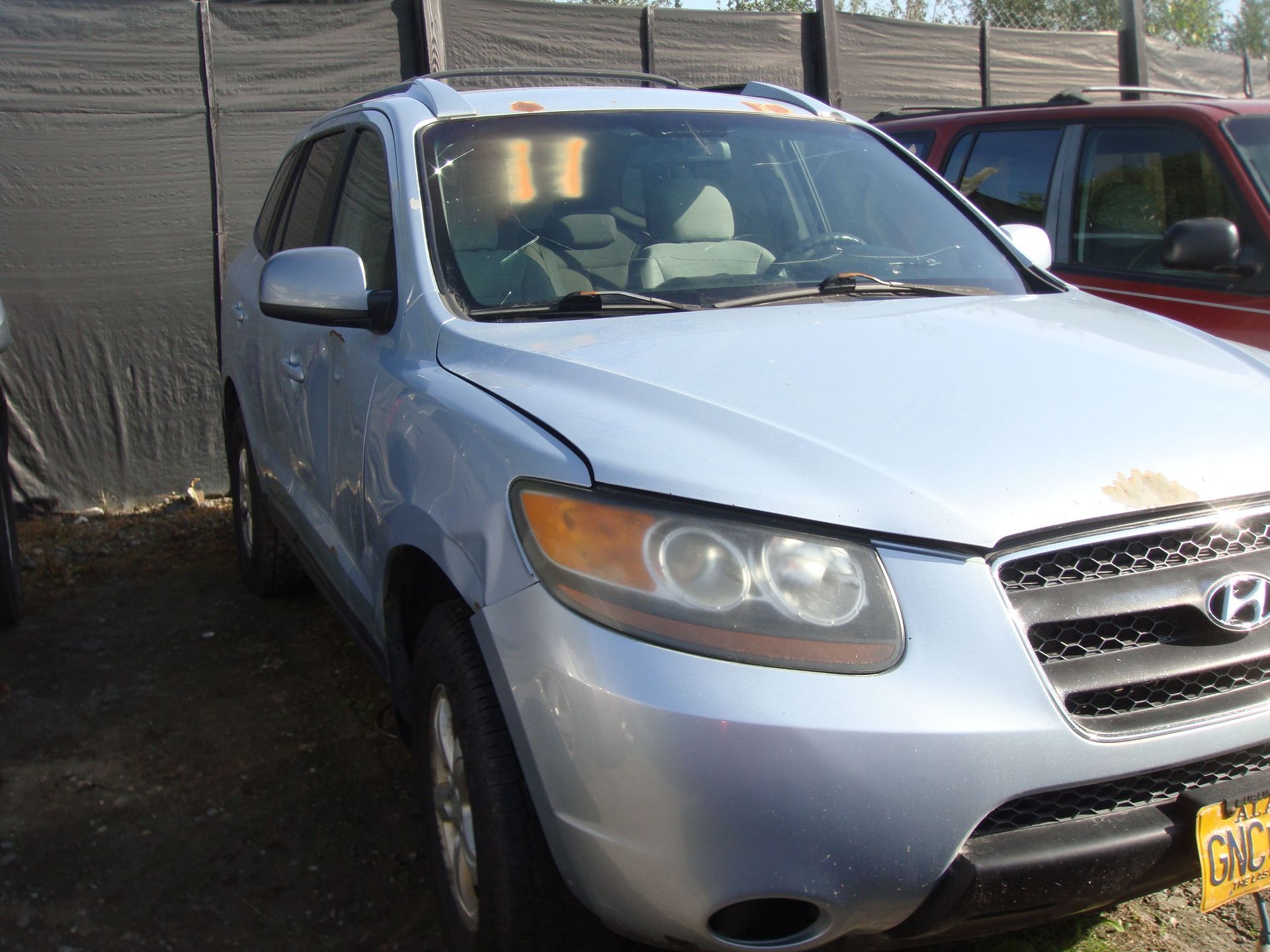 Silver SUV parked beside a red vehicle in a lot, front view