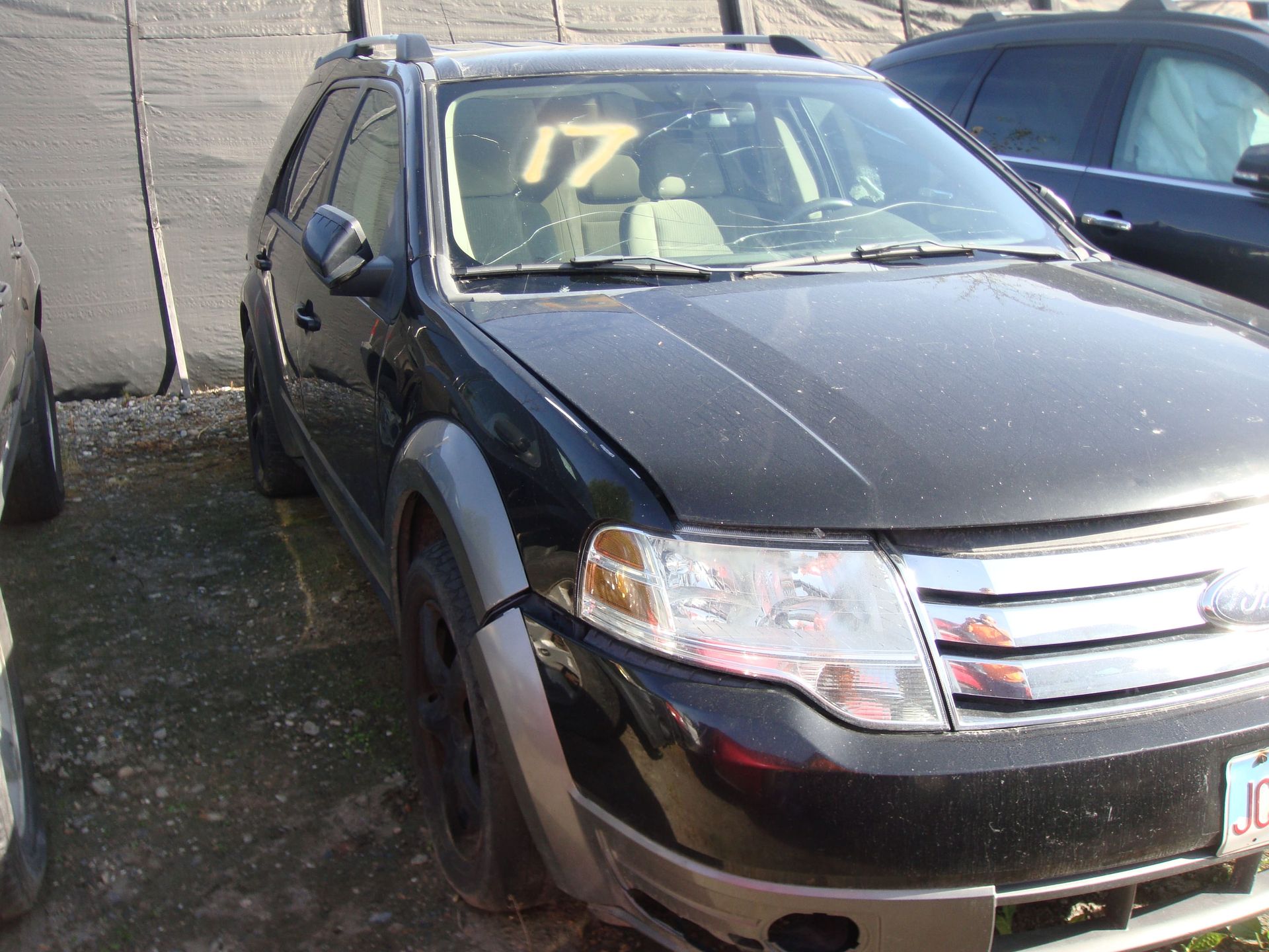 Black SUV parked in a lot, front view with yellow 17 on windshield