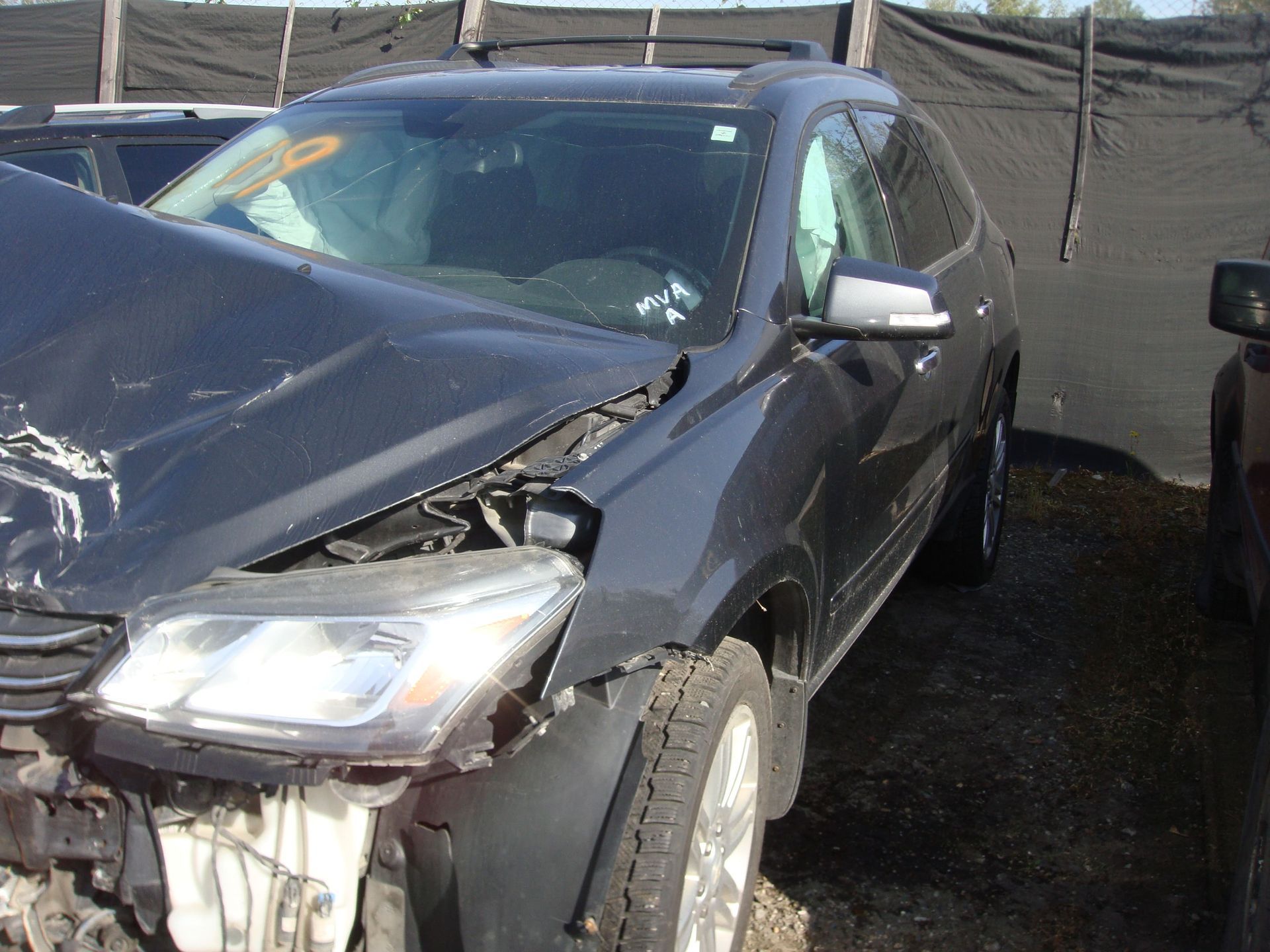 Damaged black SUV with smashed front-left corner parked outdoors