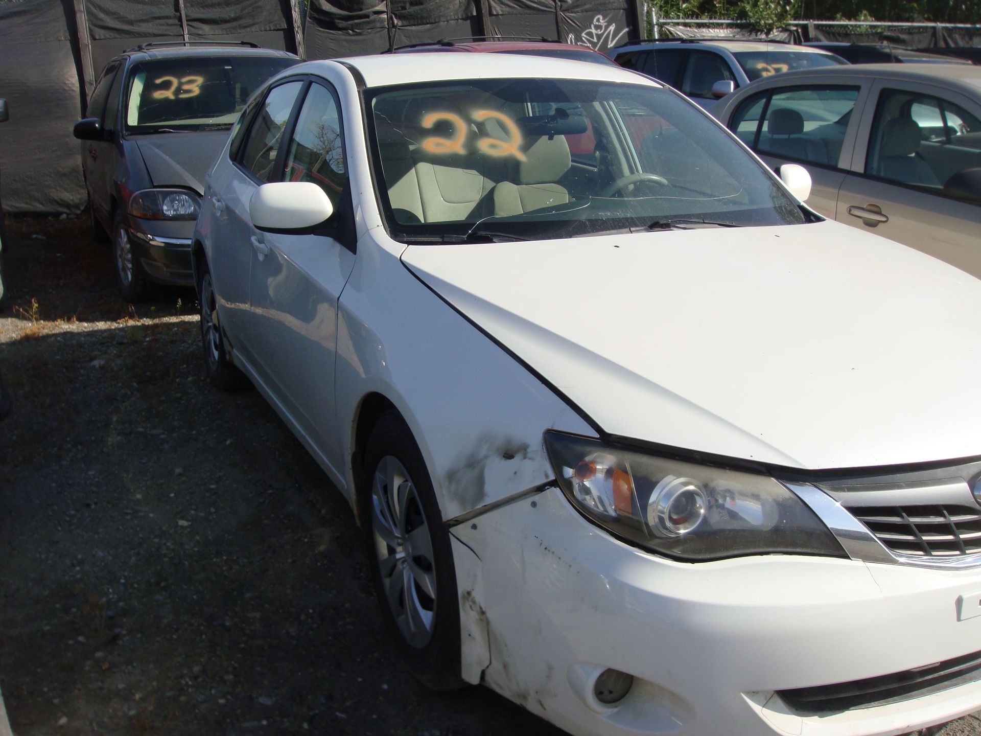 White sedan parked in a lot with other cars around it