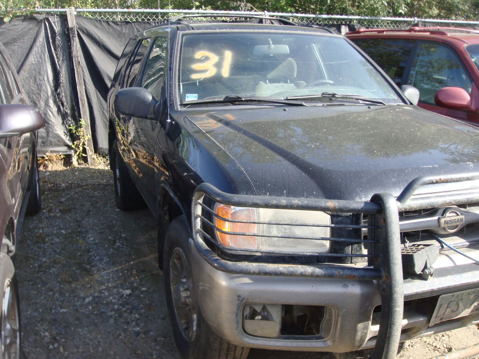 Black pickup truck parked outdoors with a large white “31” on the windshield