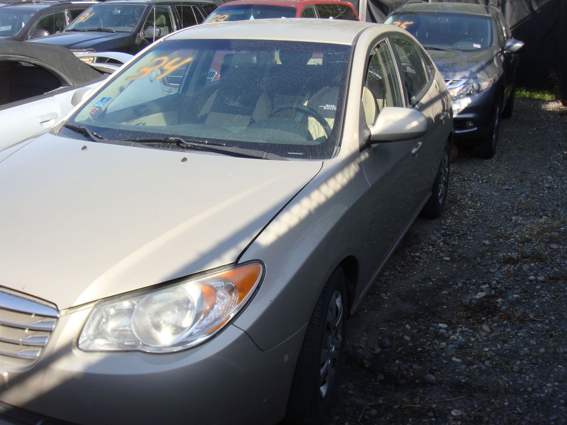 Silver sedan parked in a crowded outdoor lot, front-left view