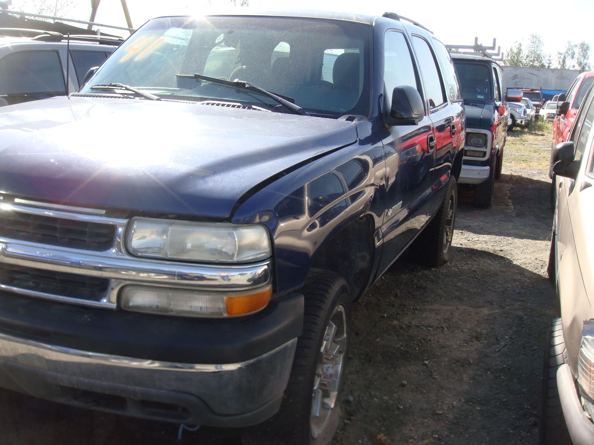 Dark blue pickup truck parked in a crowded lot, viewed from the front-left side