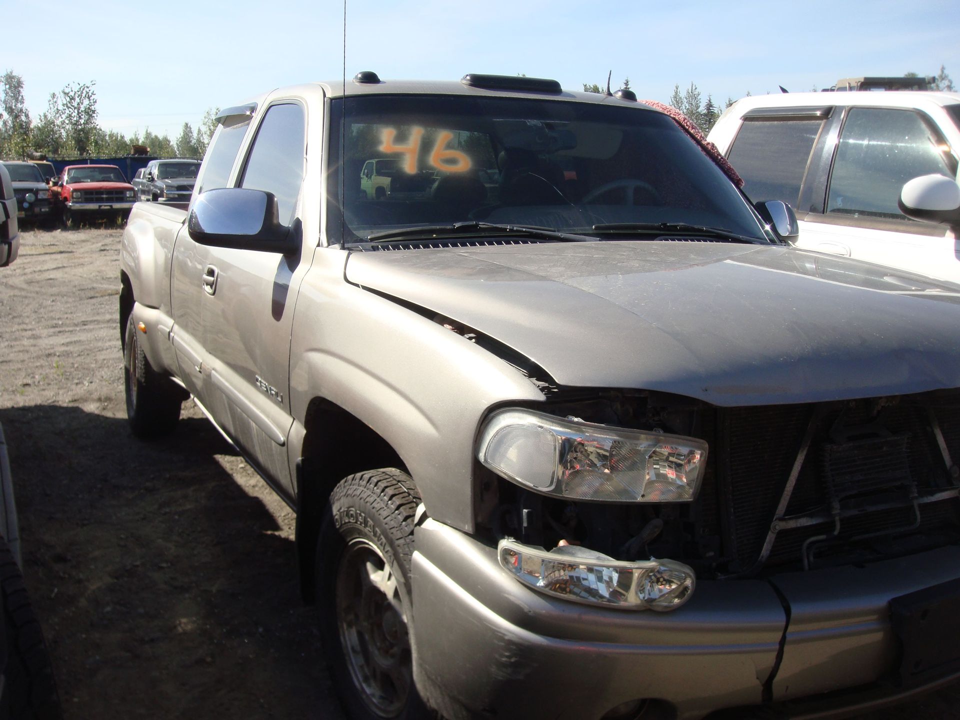 Silver pickup truck parked in a lot, front view with yellow “46” on windshield