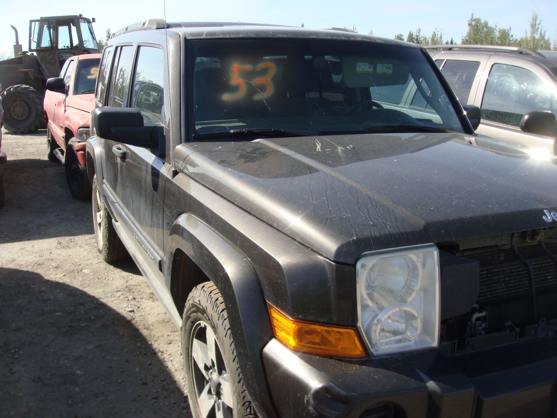 Black pickup truck parked in a lot, with a yellow “53” marked on the windshield.