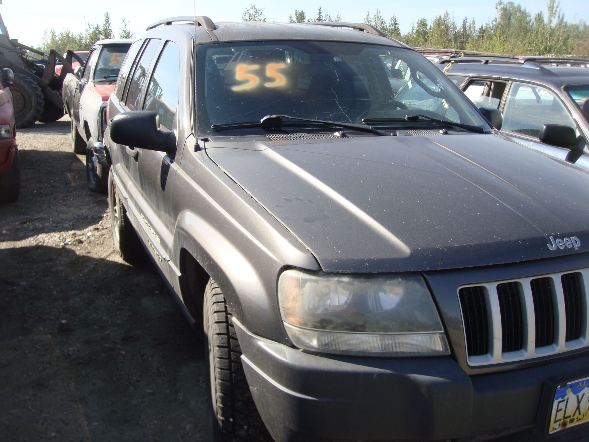 Gray Jeep SUV parked in a lot, marked “55” on the windshield.
