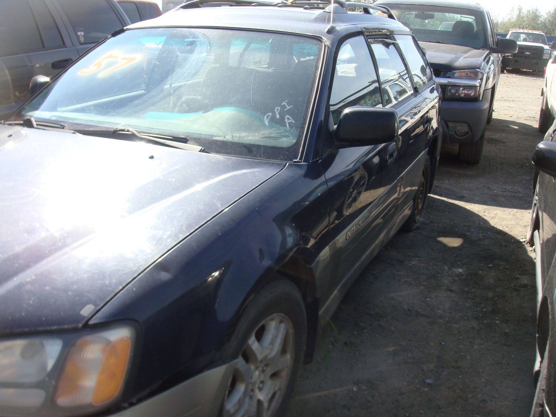 Dark blue SUV parked in a crowded lot, with other cars closely behind it.