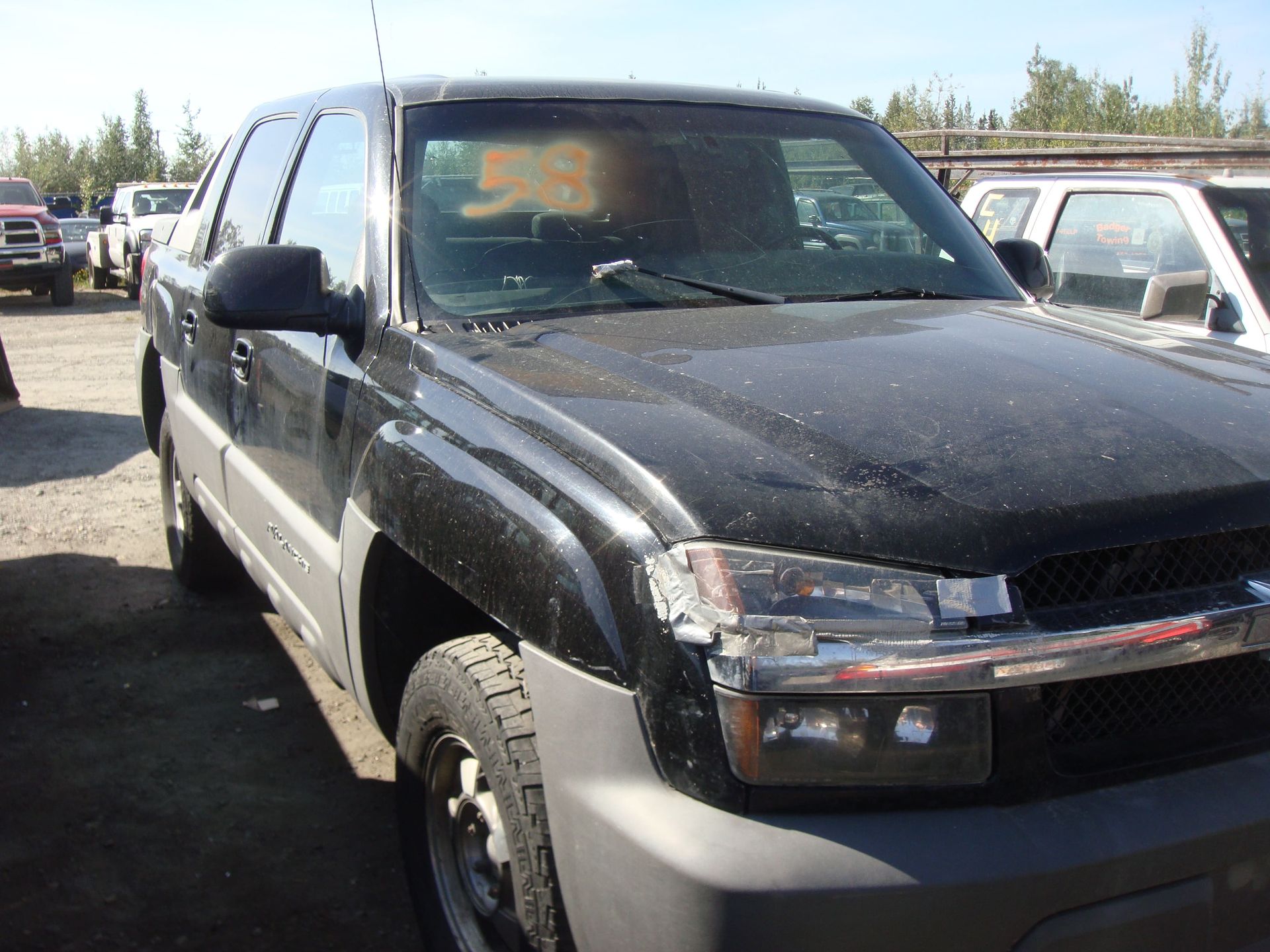 Black and silver SUV parked in a lot, front view