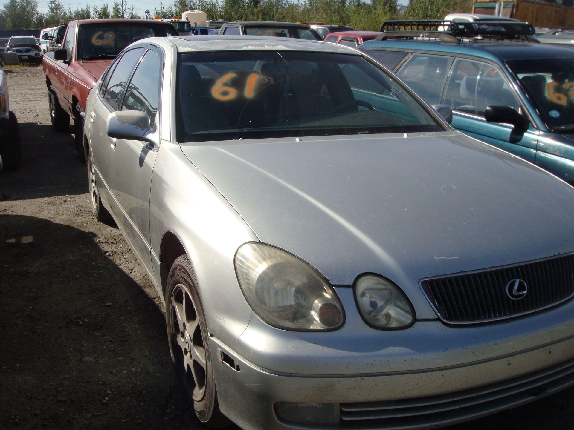 Silver Lexus sedan in a used car lot with orange number 61 on the windshield