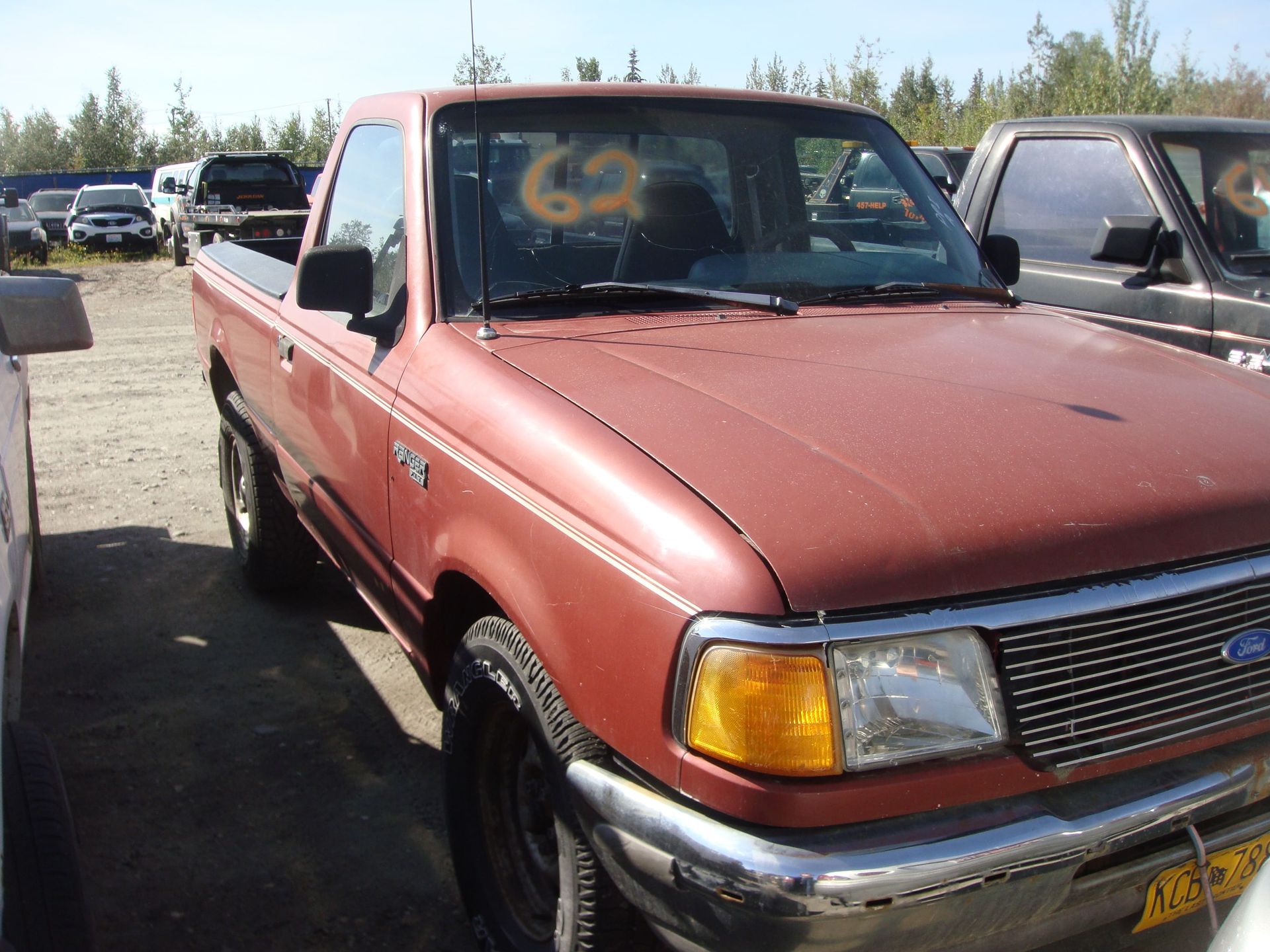 Maroon pickup truck parked outdoors in a car lot