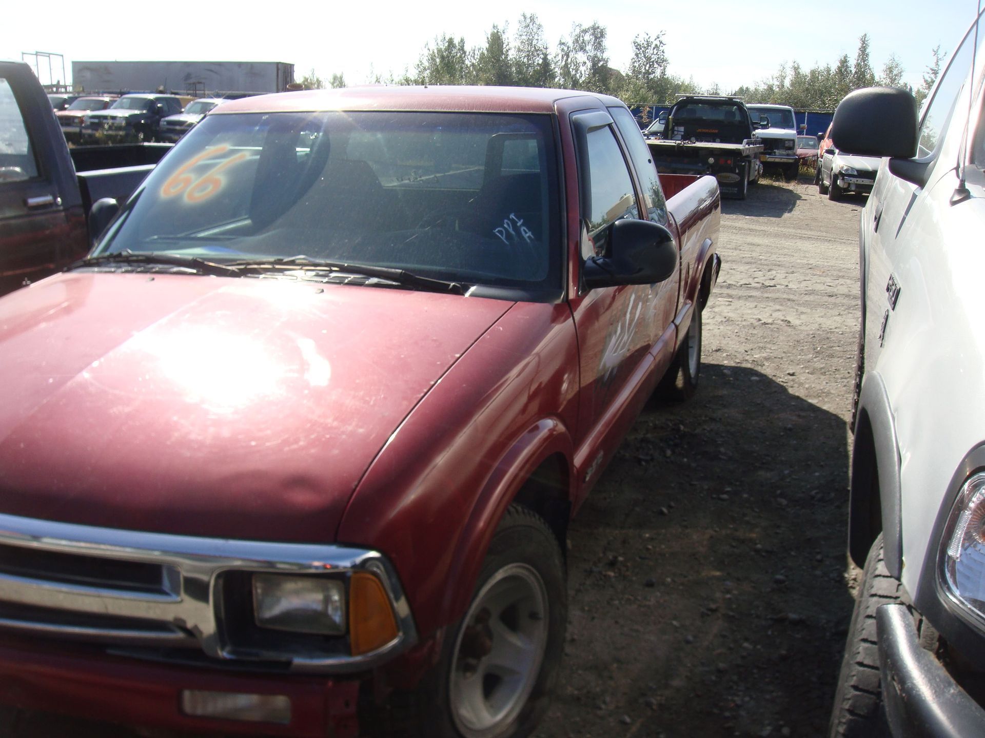 Red SUV parked in a crowded lot beside a white vehicle