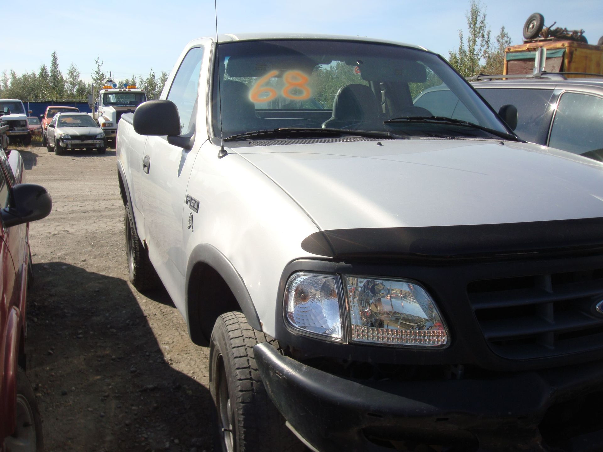 White pickup truck parked in a lot, front view with black grille and bumper