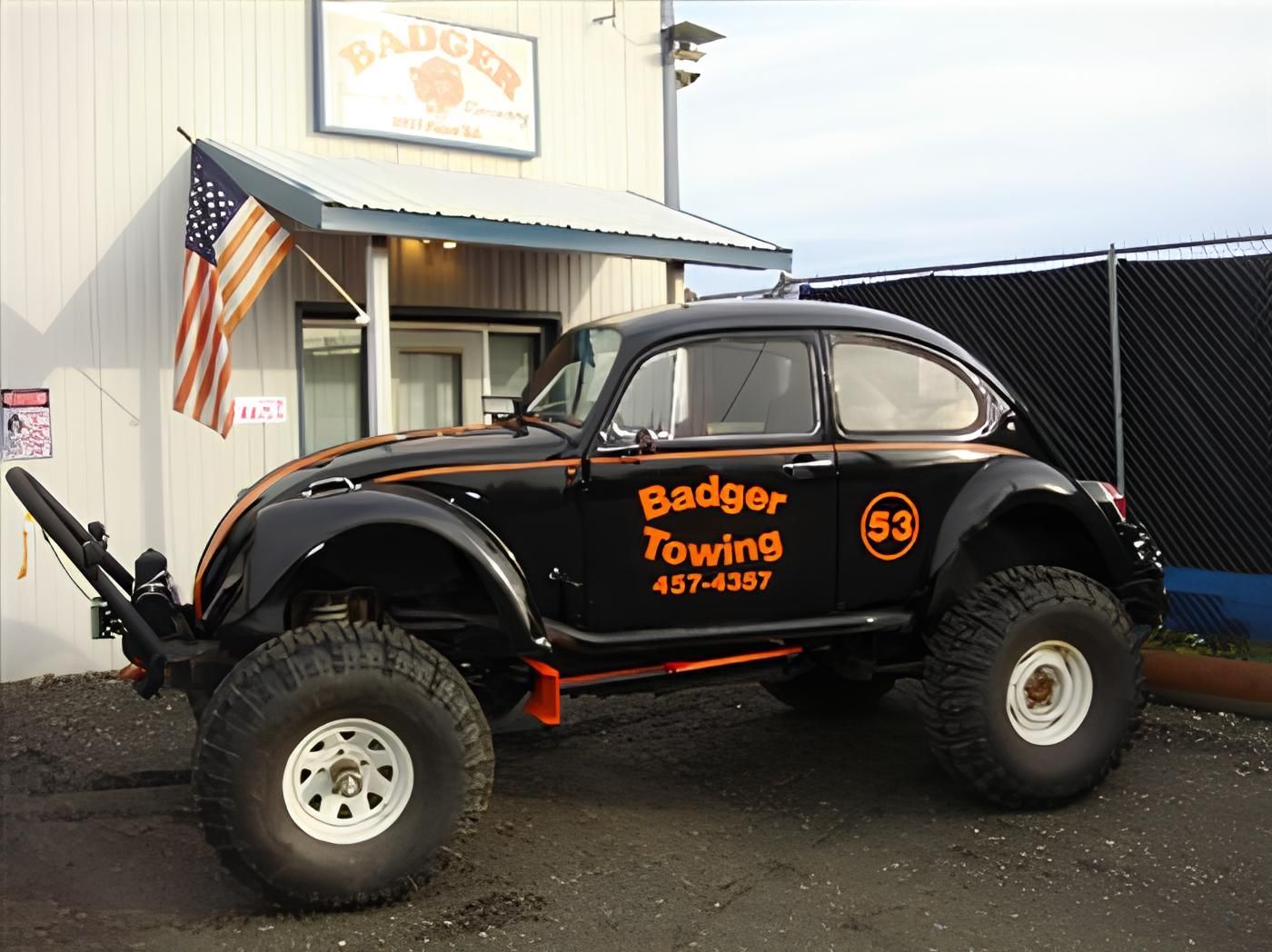 a badger towing vehicle is parked in front of a building