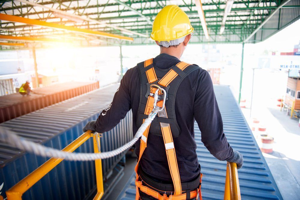 Worker Wearing Safety Harness And Hard Hat Walking On A Shipping Container — Wendy's Safety Services in Moulden, NT