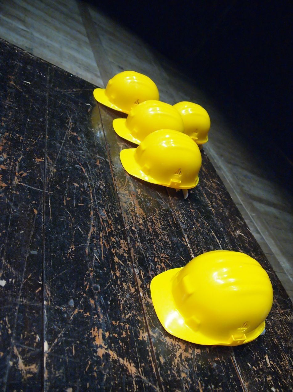 Five Yellow Construction Hard Hats On A Worn, Dark Wooden Surface — Wendy's Safety Services in Alice Springs, NT