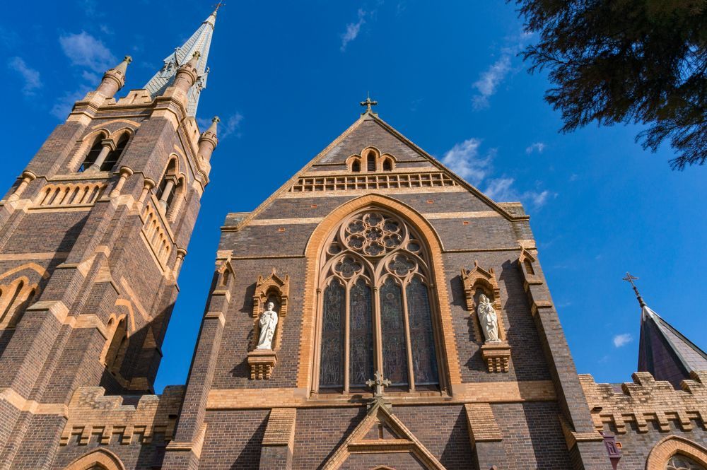 A Large Brick Church with A Steeple and Stained Glass Windows — New England Shade Sails in Armidale, NSW