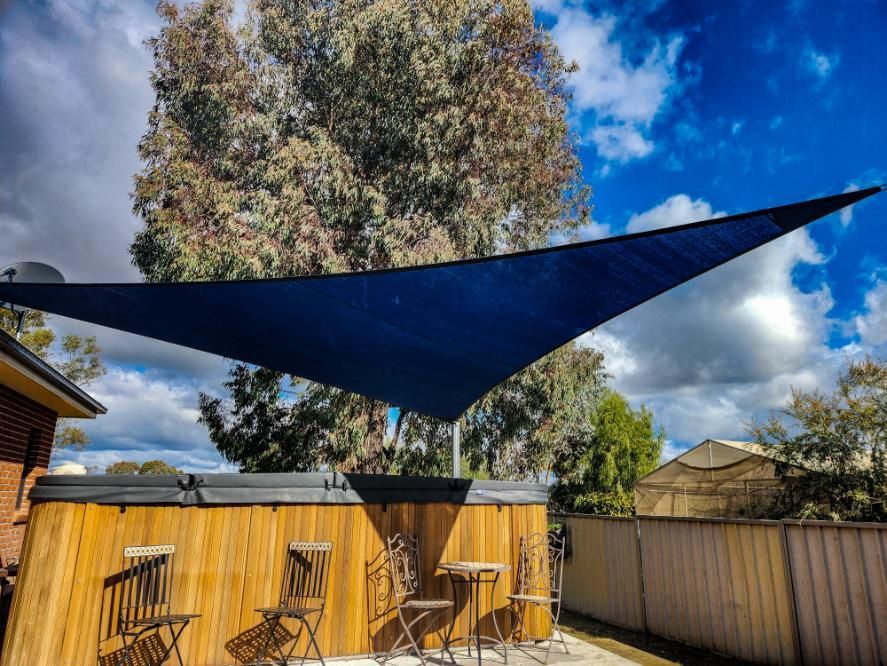 A Blue Canopy Covering a Patio Area with Tables and Chairs — New England Shade Sails in Armidale, NSW