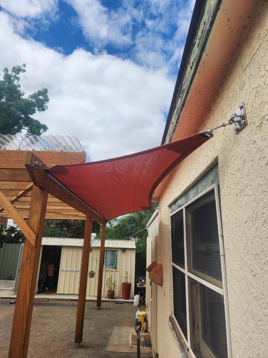 A Red Shade Sail Is Attached to The Side of A House — New England Shade Sails in Armidale, NSW