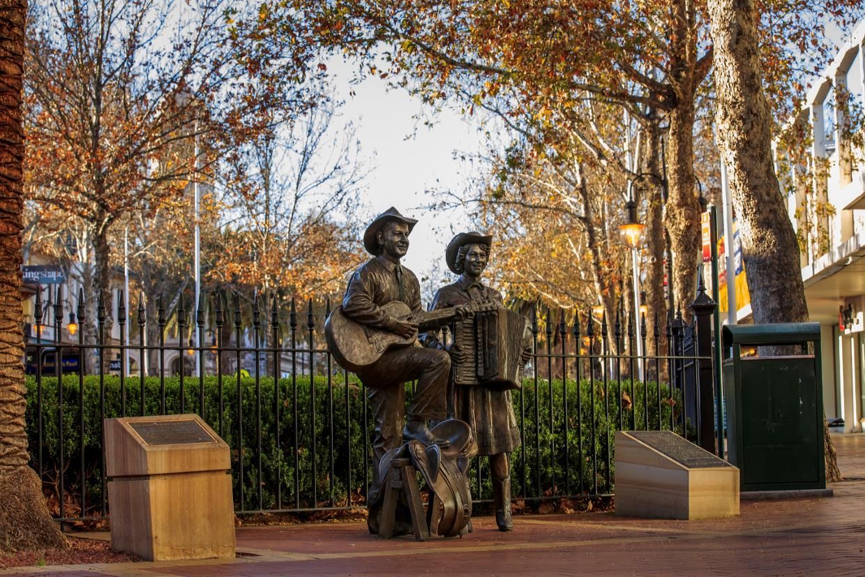 A Statue of A Man Playing a Guitar and A Woman Playing an Accordion — New England Shade Sails in Tamworth, NSW