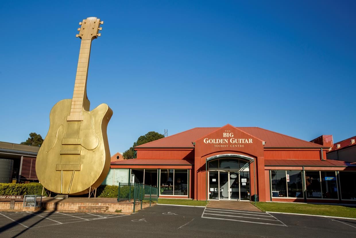 A Large Gold Guitar Is in Front of A Building — New England Shade Sails in Tamworth, NSW
