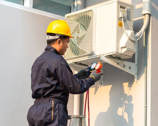 Male Technician Repairing Air Conditioner | Murfreesboro, TN | Fann Mechanical Company