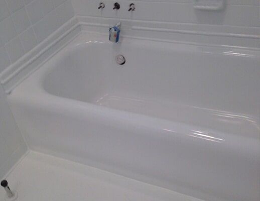 A white bathtub is sitting in a bathroom next to a white wall.