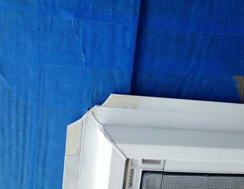 A white window with a screen is sitting on a blue cloth.