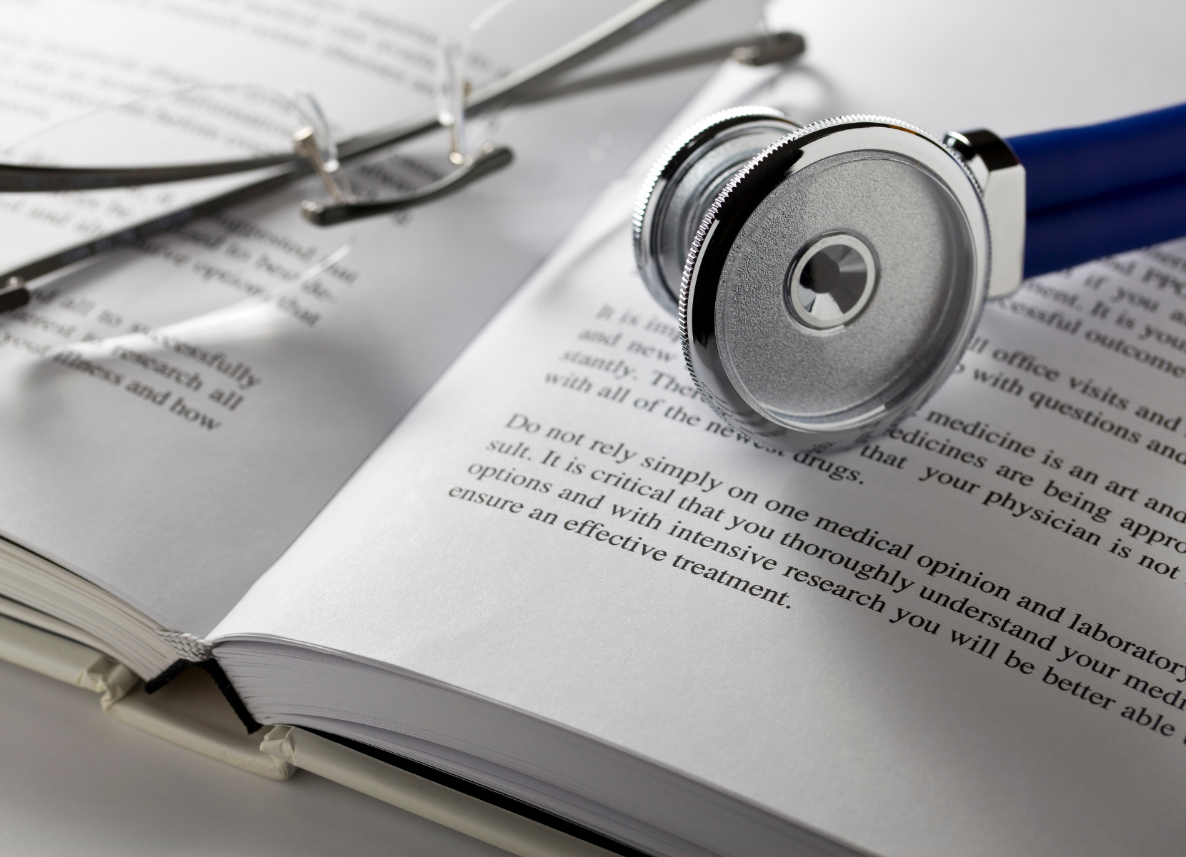 A stethoscope is sitting on top of an open book