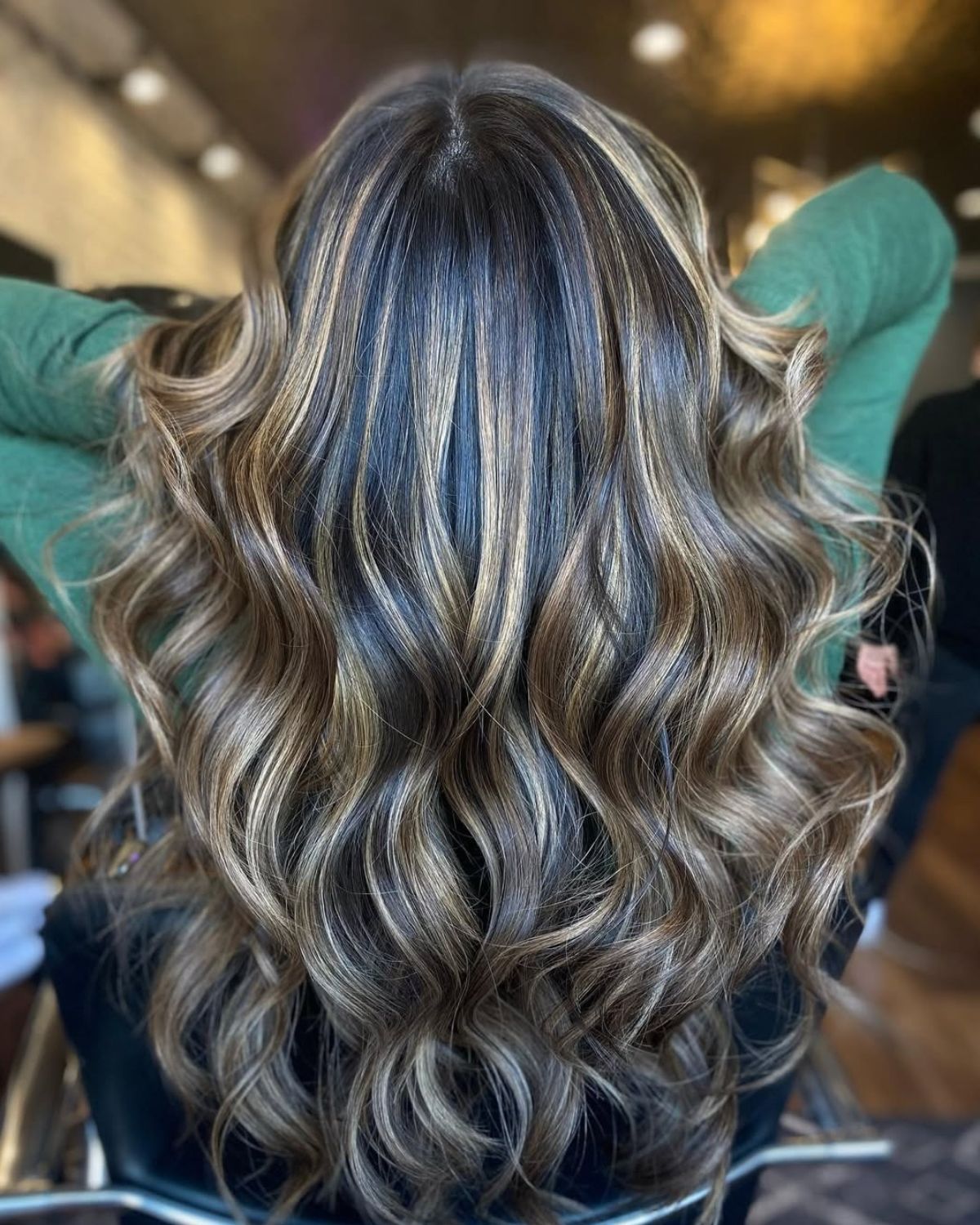 Brown wavy hair with caramel highlights.