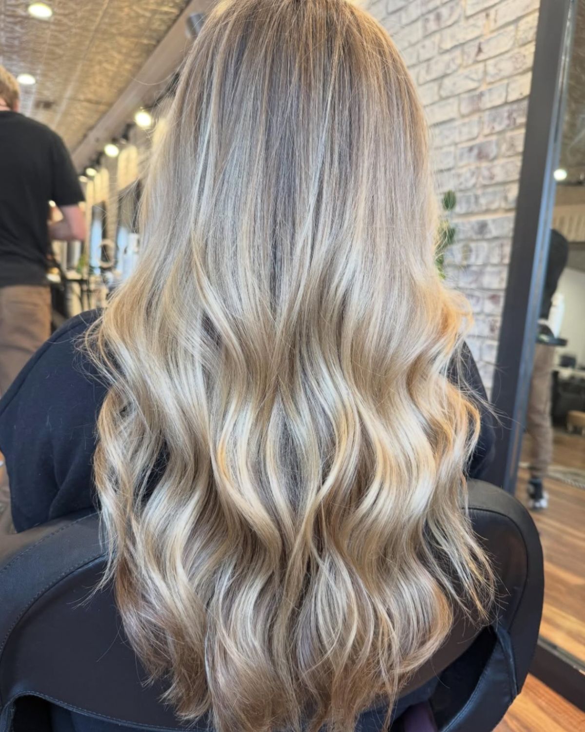 Woman with wavy blonde hair, styled at a salon.